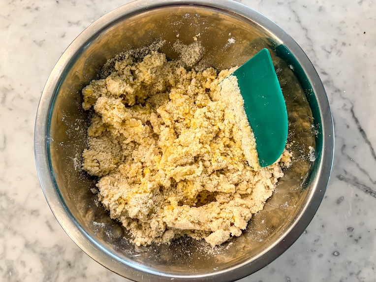 bench scraper mixing shortcrust pastry in a bowl