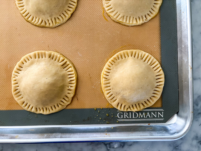 Peach hand pies on a tray before baking
