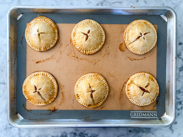 baked peach hand pies on a tray