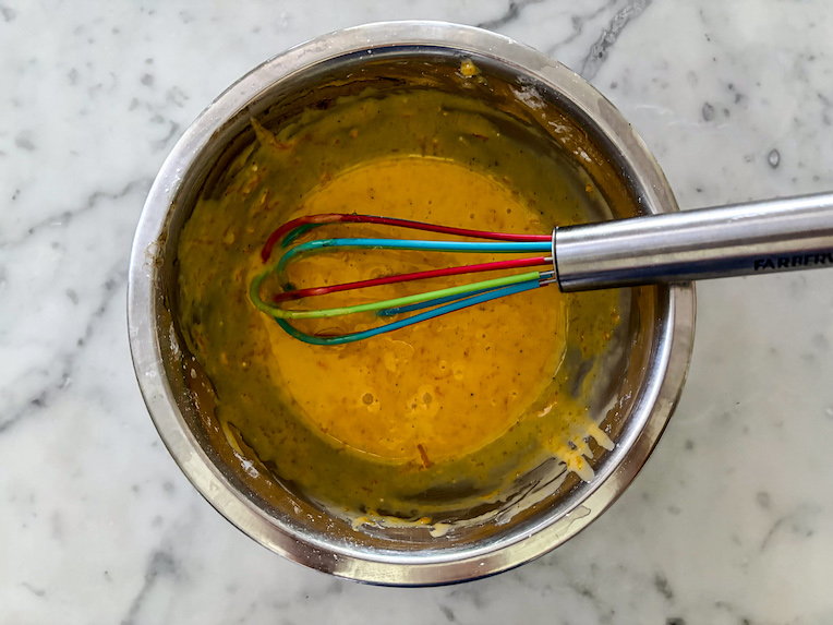 vanilla orange glaze in a small bowl with a whisk