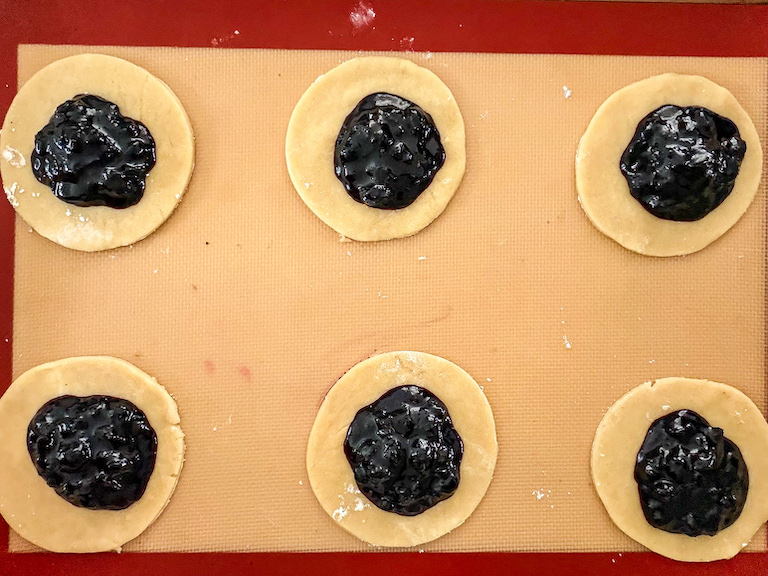 blueberry jam spooned over discs of pastry