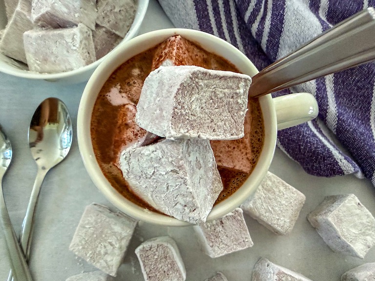 Garnishing red wine hot chocolate with homemade marshmallows