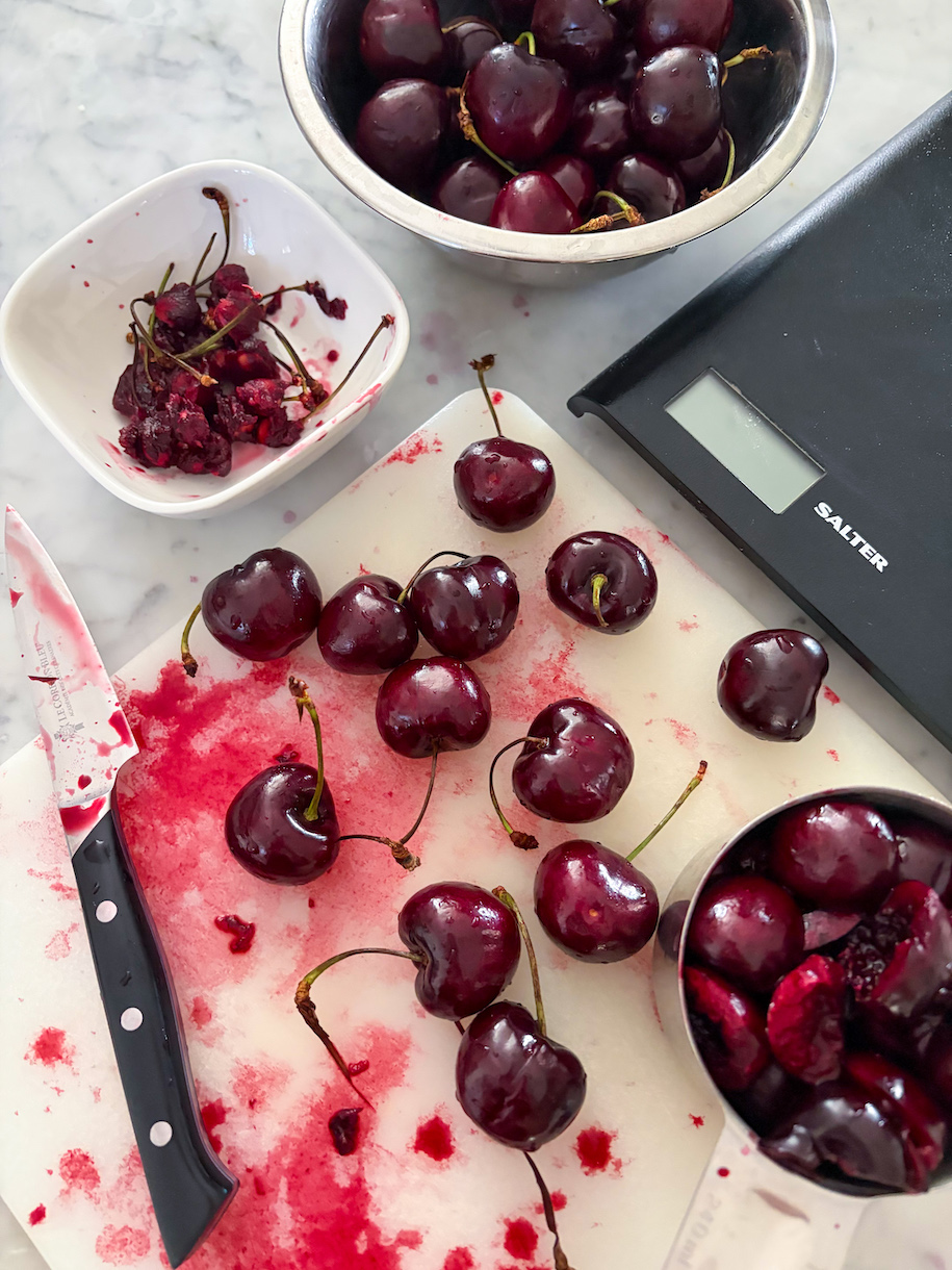 pitting fresh cherries on a cutting board