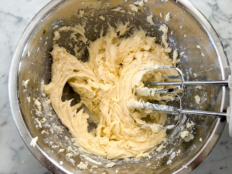 caramel frosting in a bowl with a hand mixer