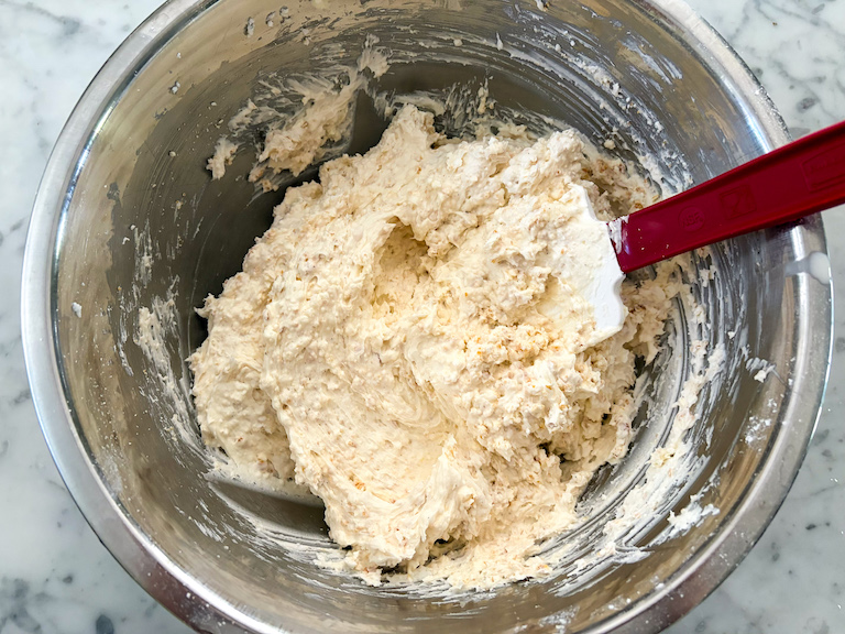 spatula in a bowl of caramel popcorn buttercream frosting