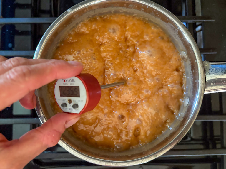 taking the temperature of a pan of caramel with a digital thermometer