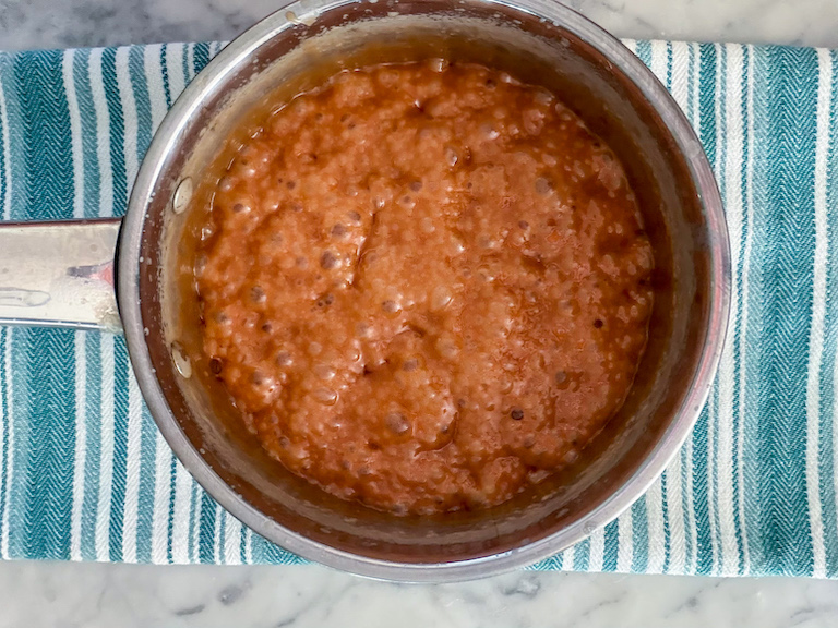 a pan of caramel sitting on a green striped towel