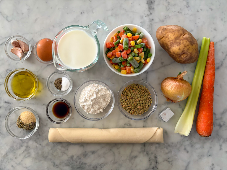 ingredients for making lentil pot pie, arranged on a marble surface