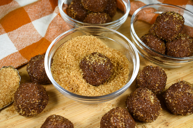a pumpkin truffle in a bowl of demerara sugar
