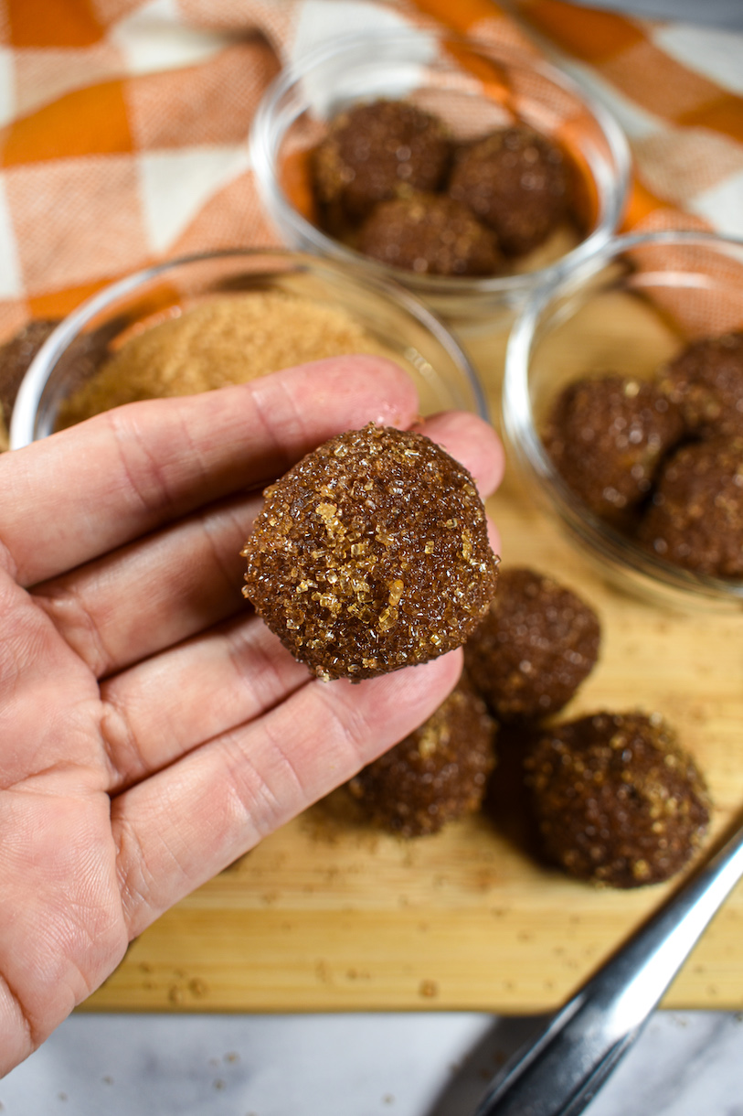 hand holding a milk chocolate pumpkin spice truffle