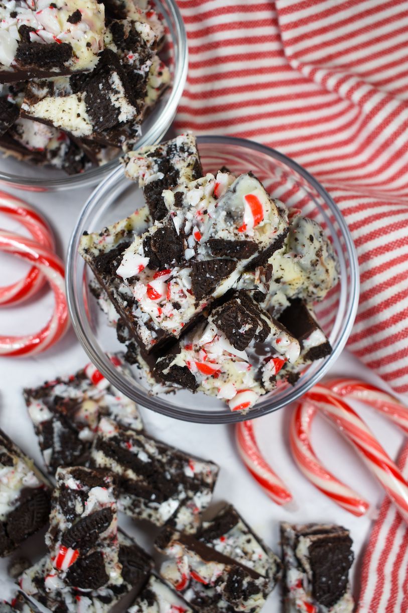 a bowl of oreo peppermint bark surrounded by candy canes