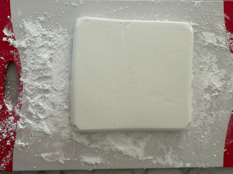 slab of marshmallow on a dusted cutting board