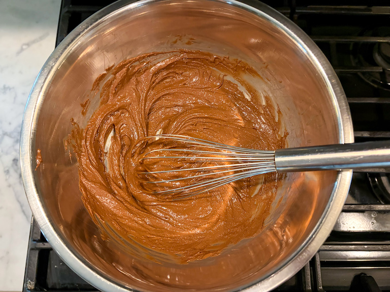 melted chocolate in a bowl with a whisk