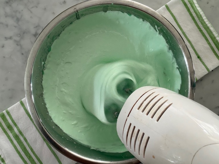 mixing peppermint marshmallow fluff in a mixing bowl