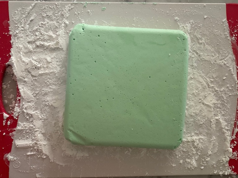 slab of peppermint marshmallow on dusted cutting board