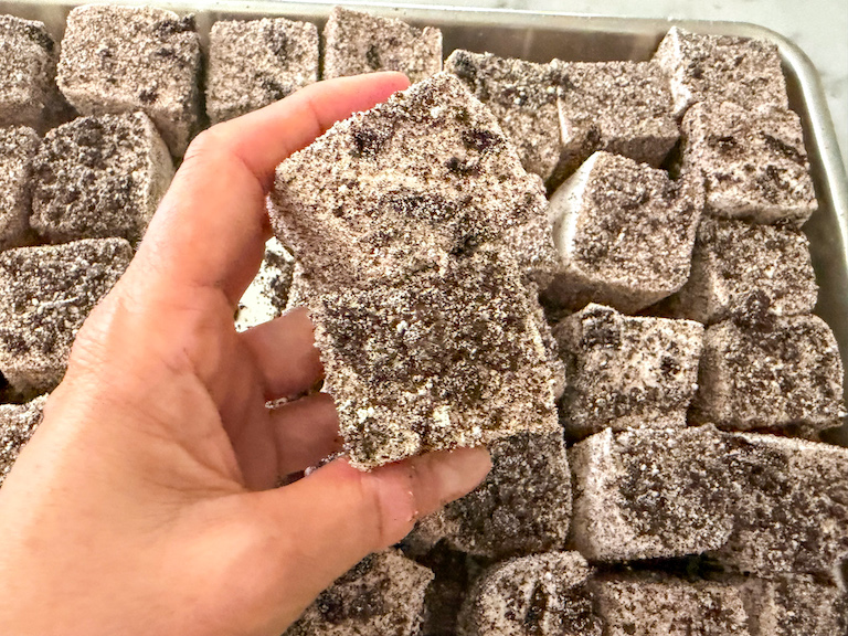 Hand holding two cookies and cream marshmallows