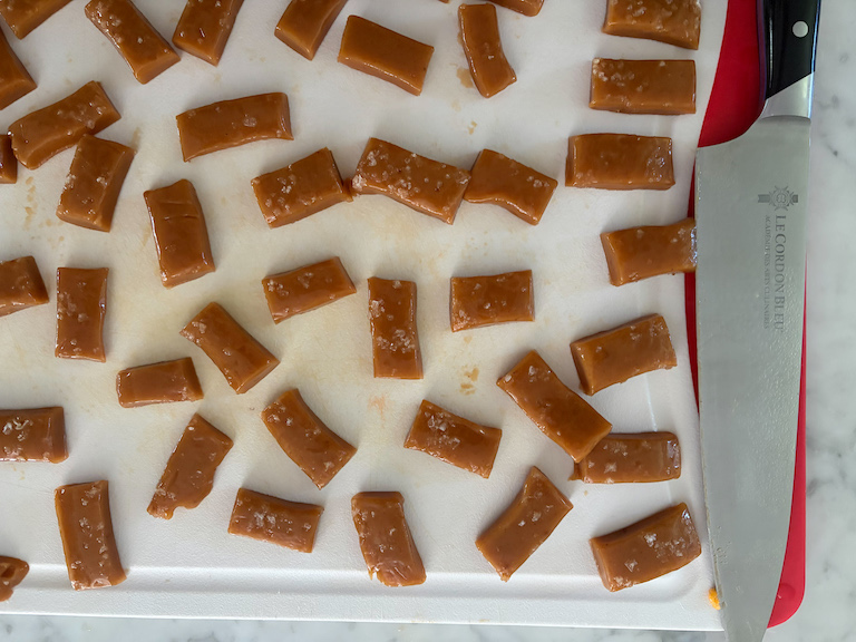 caramels on a cutting board with a knife