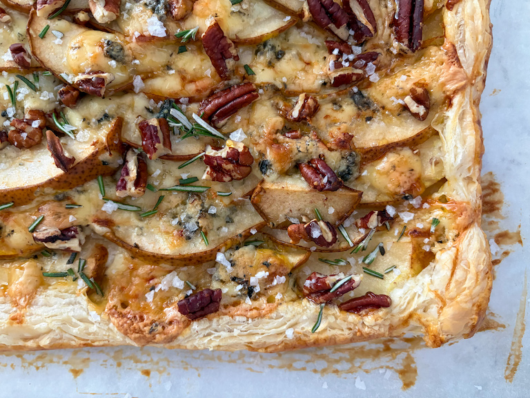 a puff pastry tart with pears, blue cheese, nuts, rosemary, and honey, after baking