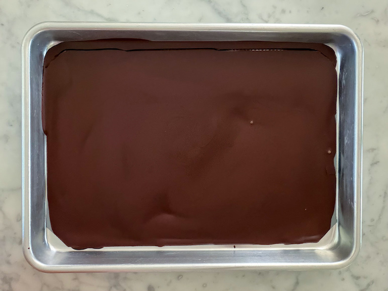dark chocolate spread across a quarter sheet tray