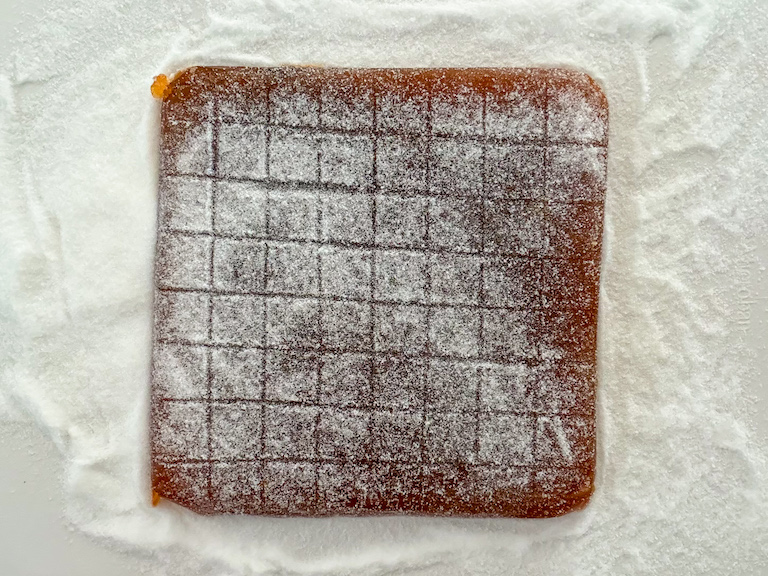 a slab of sugar coated gummy candy on a white surface