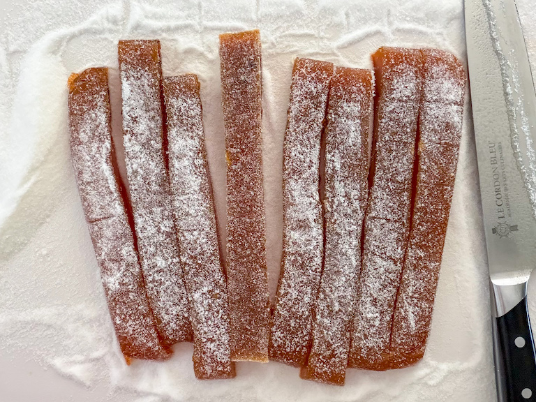 slicing carrot candy with a sharp chef's knife