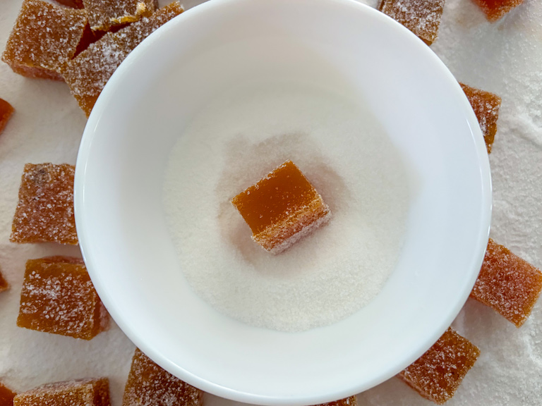 carrot gummy candy square in a bowl of sugar