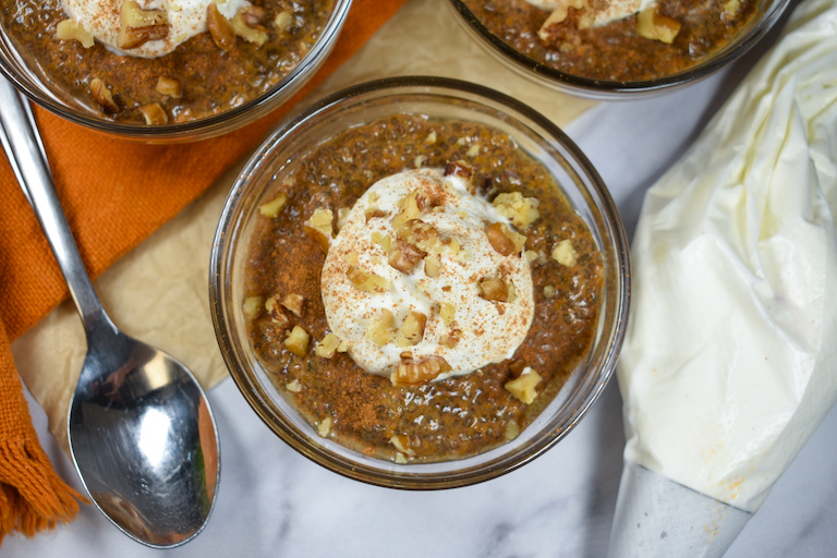 a dish of pumpkin chia pudding garnished with whipped cream