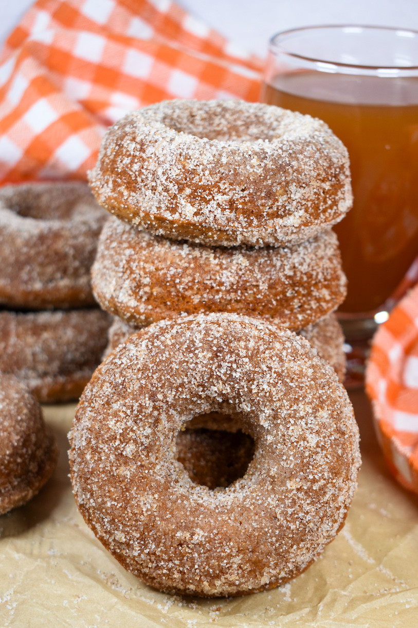 baked apple cider donuts and an orange checkered tea towel