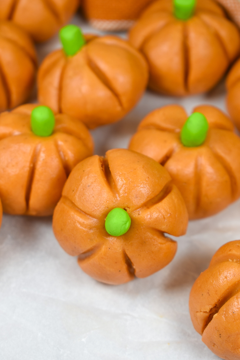orange and green peanut butter pumpkins on a white surface