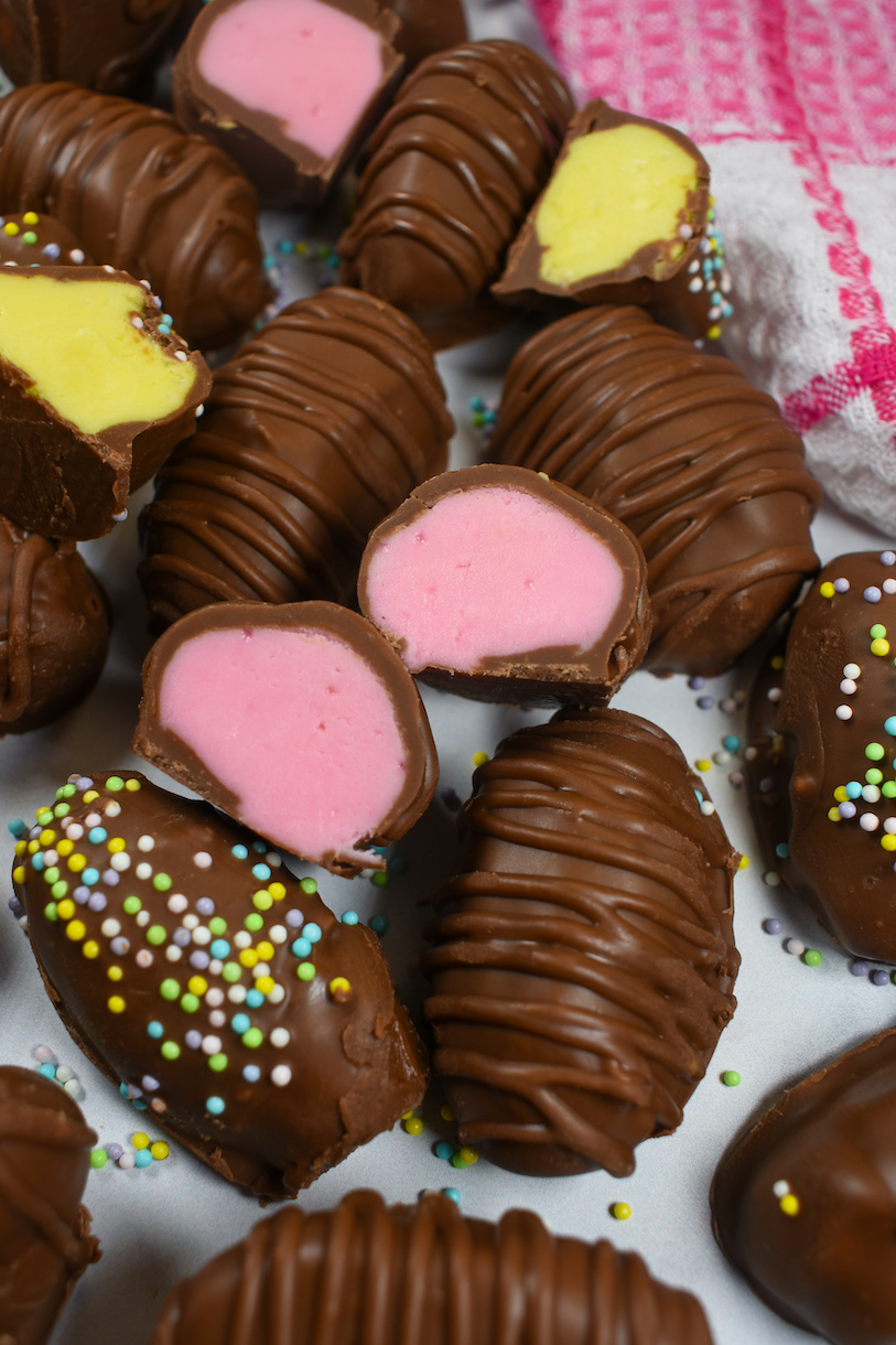 buttercream eggs cut in half revealing pink and yellow centers