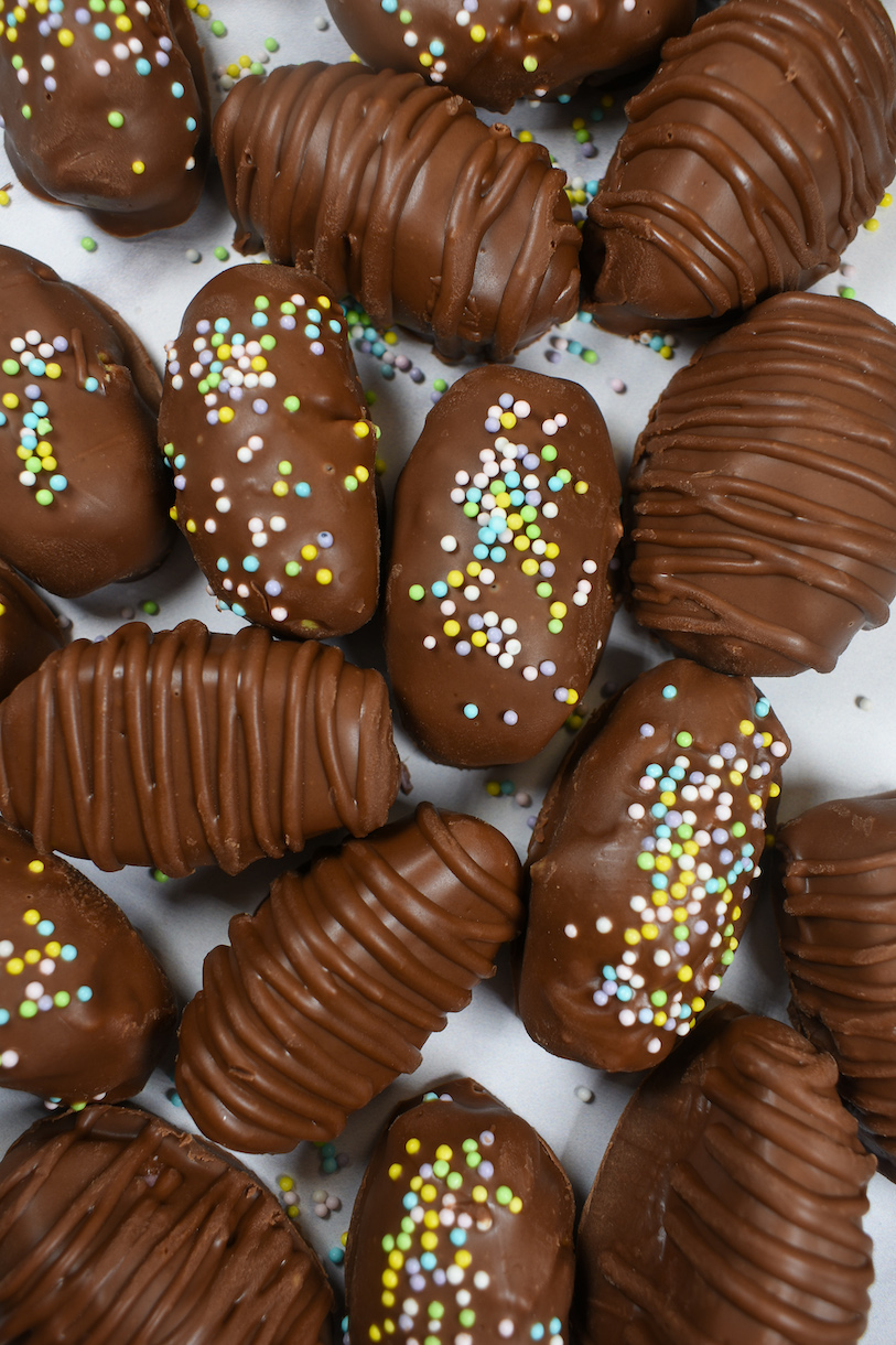 buttercream eggs decorated with piped chocolate and pastel nonpareils