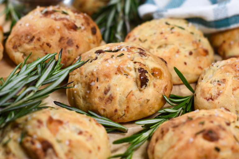 blue cheese dinner rolls and rosemary sprigs on a sheet of parchment