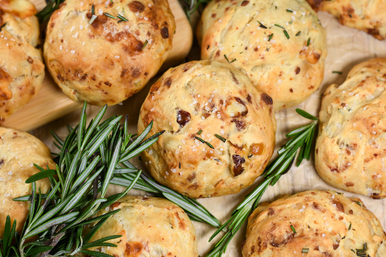 blue cheese rolls and rosemary sprigs on brown parchment