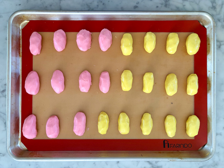 pink and yellow buttercream egg centers on a tray