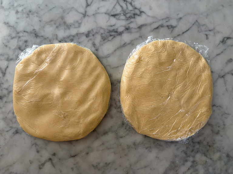 two discs of sand tart dough on a marble surface