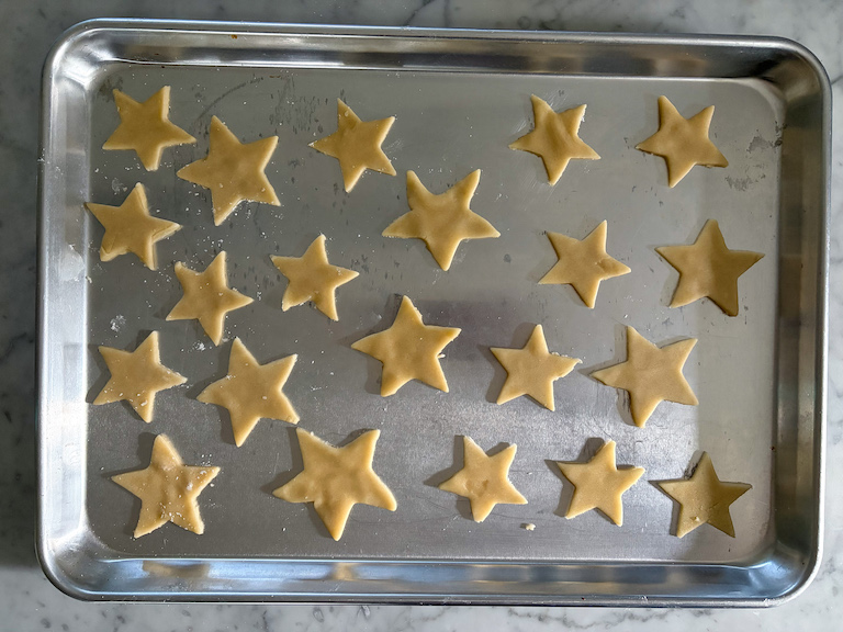 star shaped sand tarts arranged on a metal tray before baking