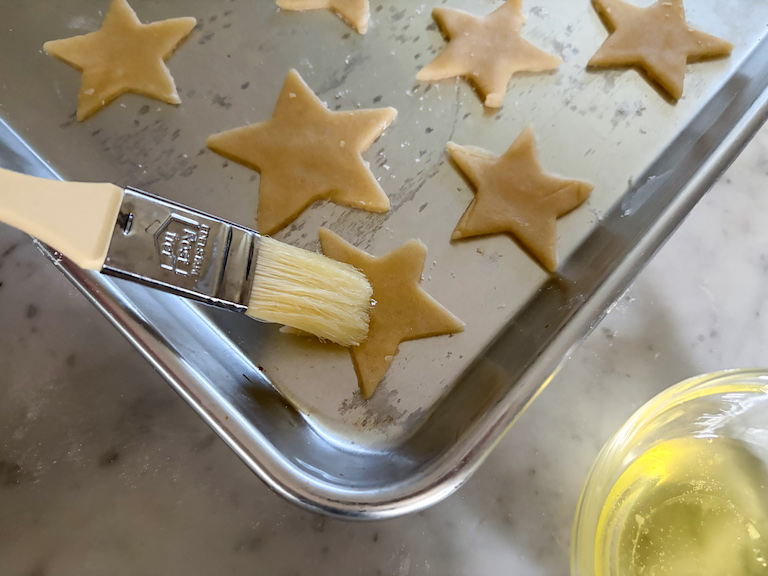 pastry brush brushing sand tarts with egg white