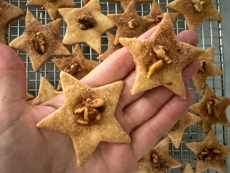 hand holding two star shaped sand tart cookies