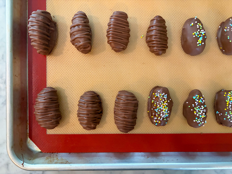chocolate dipped buttercream eggs on a tray