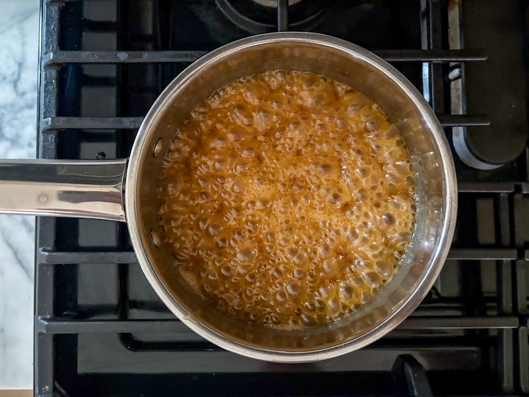 caramel bubbling in a pan on the stovetop