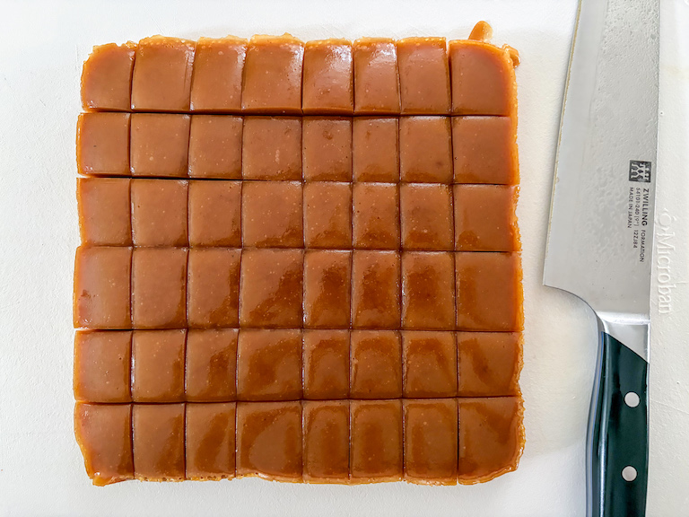 slicing pumpkin caramels with a chef's knife