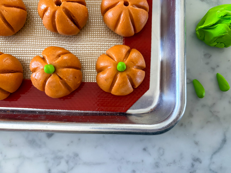 adding fondant stems to peanut butter pumpkins