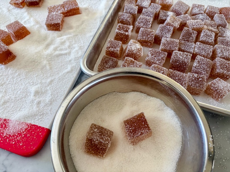 rolling apple jelly candy in a bowl of sugar