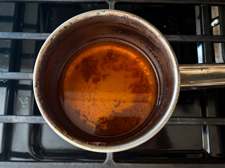 apple cider reducing in a pan on the stovetop