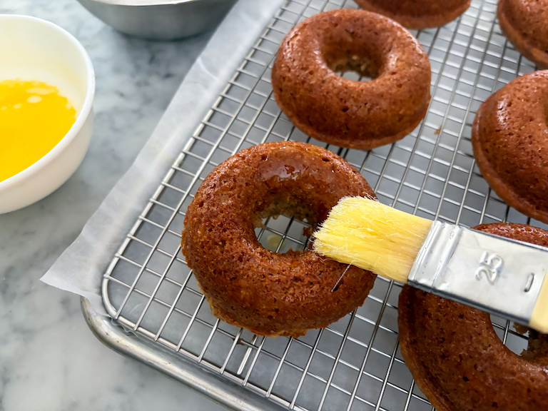brushing donuts with melted butter