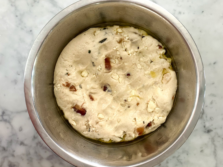 bread dough punched down in a metal bowl