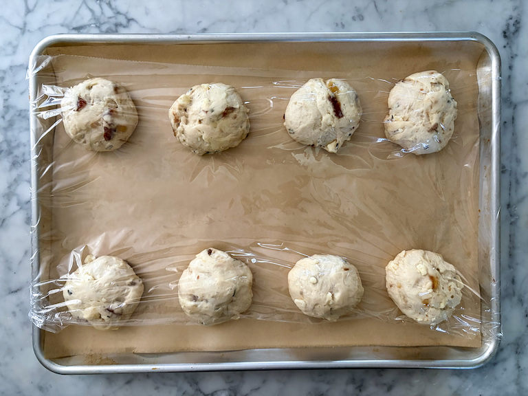 dinner rolls rising on a tray
