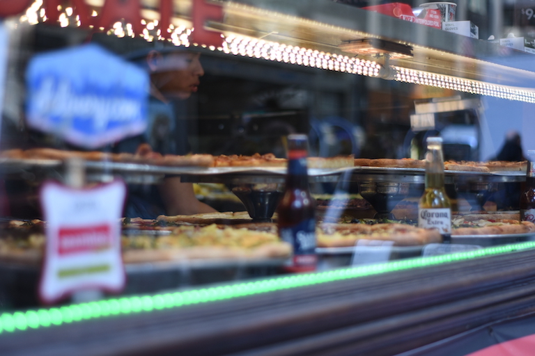 Looking in the window of a New York pizzeria