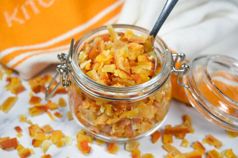 a jar of mixed citrus peels and a spoon