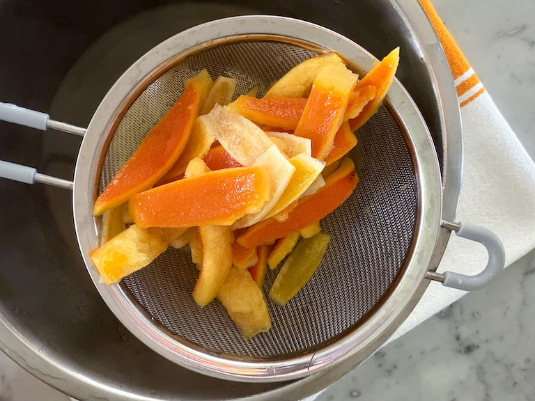 passing candied peels through a strainer